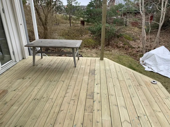Terrasse avec table, terrain boisé en arrière-plan
