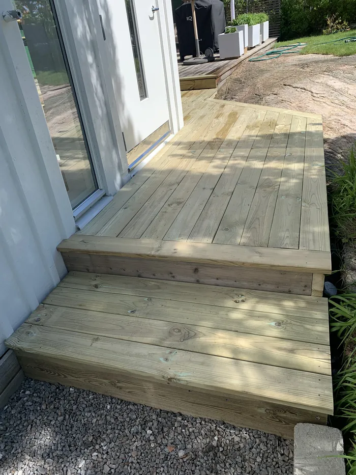 Trappsteg i trä vid entré