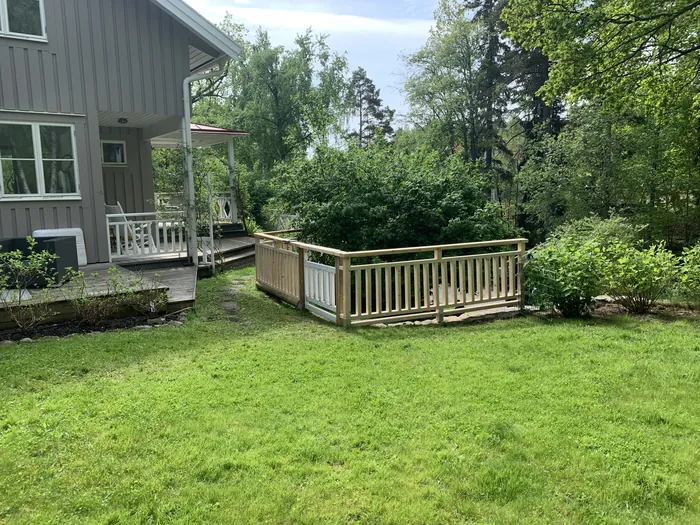 Terrasse avec garde-corps dans un jardin verdoyant