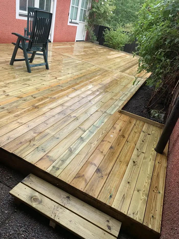 Terrasse avec une chaise, près d'une maison rouge