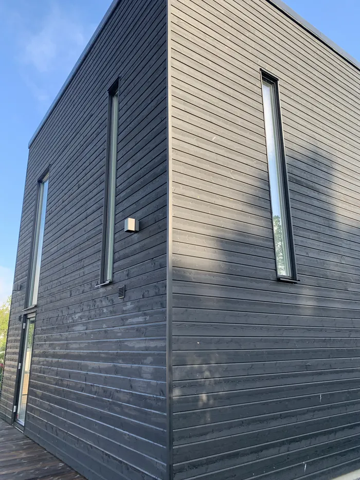 Bardage en bois peint en noir sur une façade