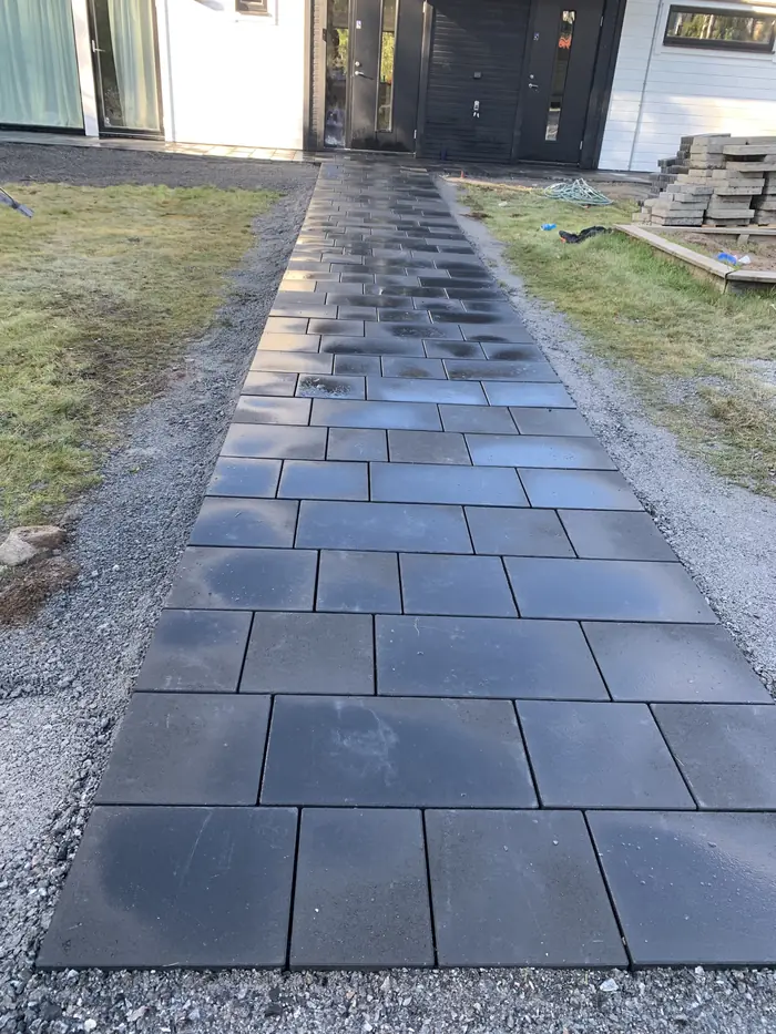 Stenlagd gång i mörk betongsten